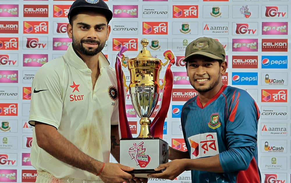 India’s captain Virat Kohli and Bangladesh’s captain Mushfiqur Rahim pose for photographs with the winners trophy at the end of the final day of the cricket test match against Bangladesh in Fatullah, Bangladesh.