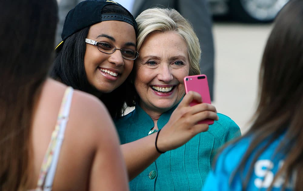 Democratic presidential hopeful Hillary Rodham Clinton poses for a selfie with Olivia Keller, after speaking to supporters during a campaign house party, in Burlington, Iowa.