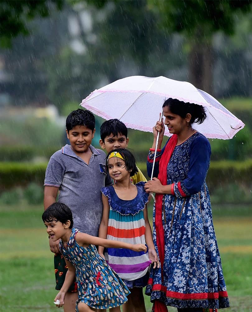 Children enjoy monsoon shower in New Delhi.