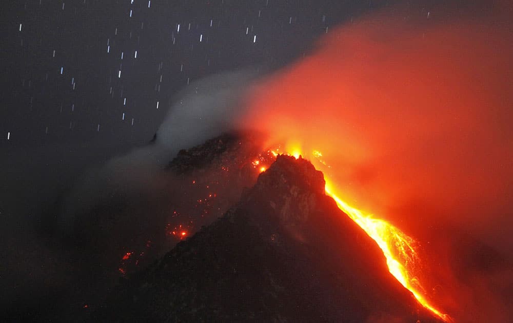 In this photo taken with slow shutter speed, hot lava flows from the crater of Mount Sinabung as seen from Tiga Serangkai, North Sumatra, Indonesia.