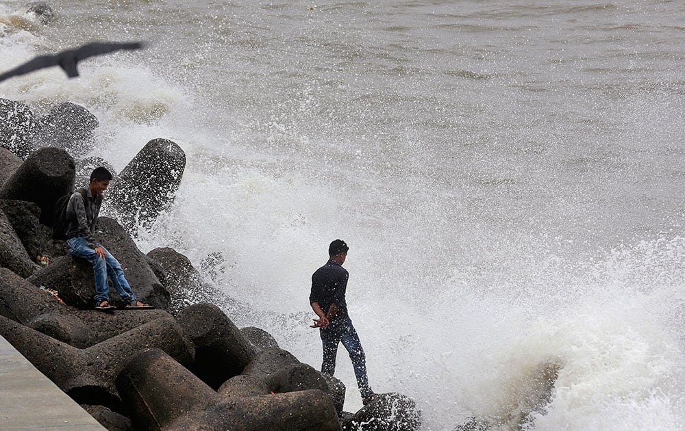 Indians enjoy high tide waves on the Arabian Sea coast in Mumbai.