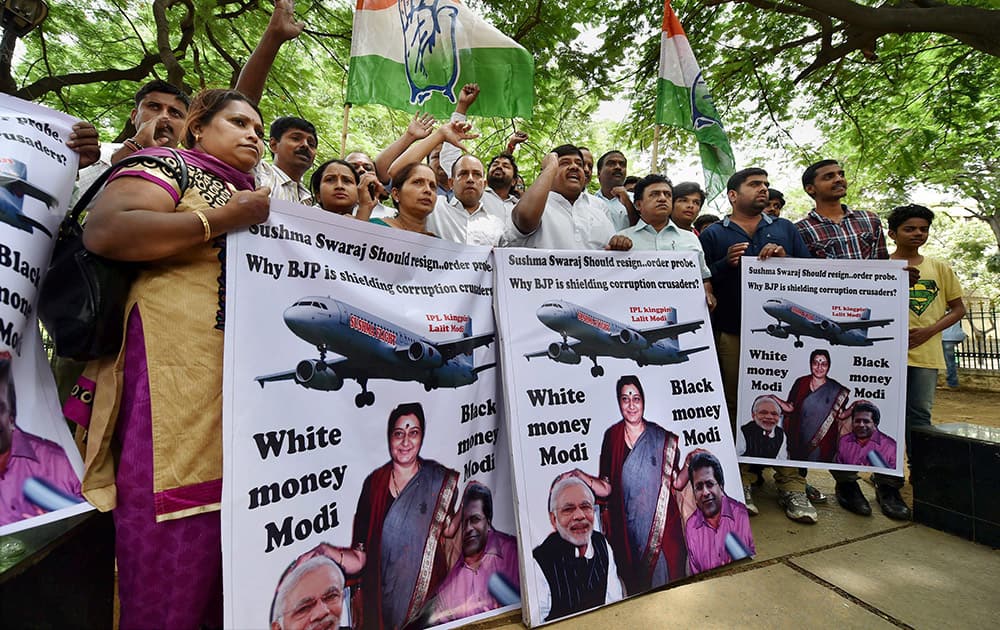 Members of Youth Congress hold posters and shout slogans against External Affairs Minister Sushma Swaraj in the row over helping scam-tainted former IPL Commissioner Lalit Modi obtain British travel papers,in Bengaluru.
