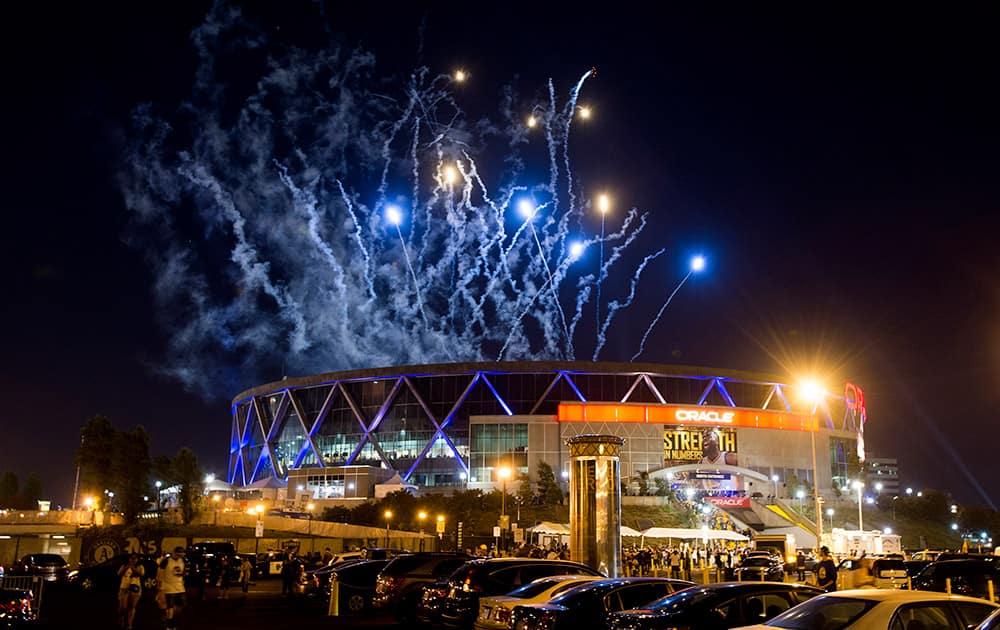 Fireworks leave trails of smoke over Oracle Arena , in Oakland, Calif.