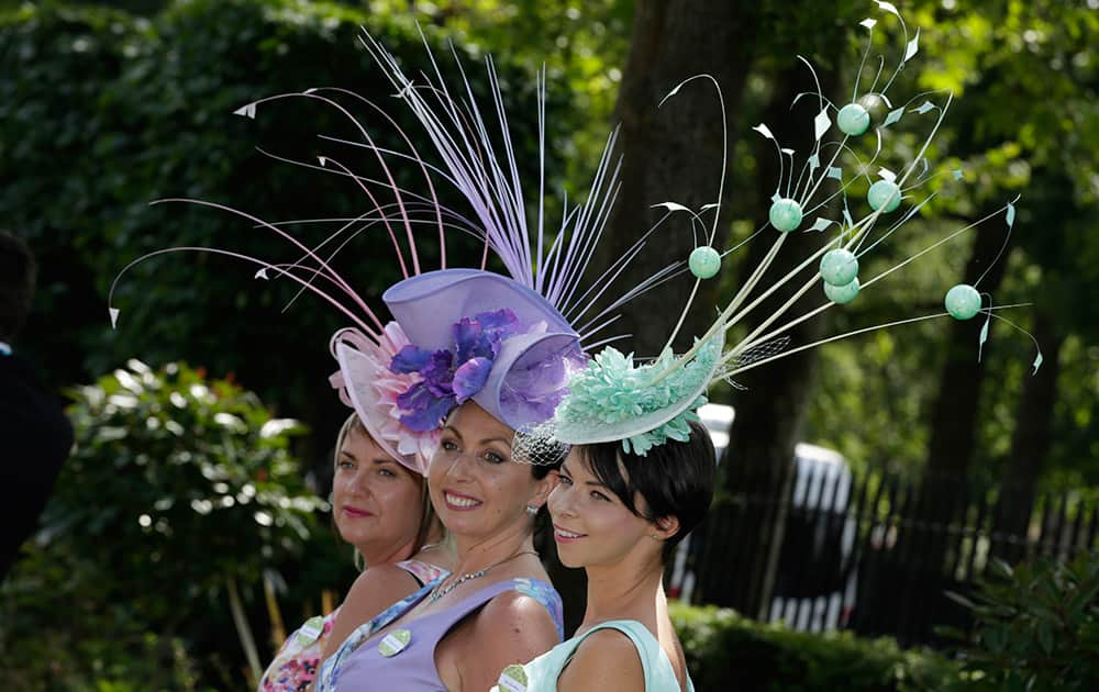 Three women pose for photographers on the first day of Royal Ascot horse racing meet at Ascot, England.