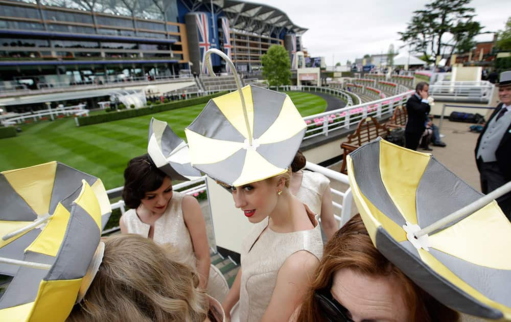 Umbrella hats worn by a singing group as they pose next to the parade ring on the second day of Royal Ascot horse racing meet at Ascot, England.