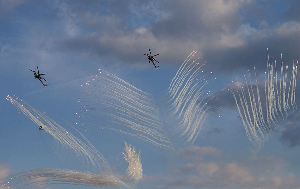 Russian Army's MI-28 attack helicopters fire flares during a show at a shooting range in Alabino, outside of Moscow, Russia.