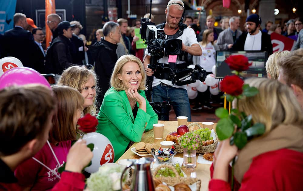 Danish Prime Minister and head of the Social Democrats Helle Thorning-Schmidt smiles as she has breakfast during a live TV show on the floor of the Central Station in Copenhagen, Denmark. Danes are voting Thursday in parliamentary elections that will determine whether the center-left government of Thorning-Schmidt can continue or whether the center-right opposition will be back at the helm.