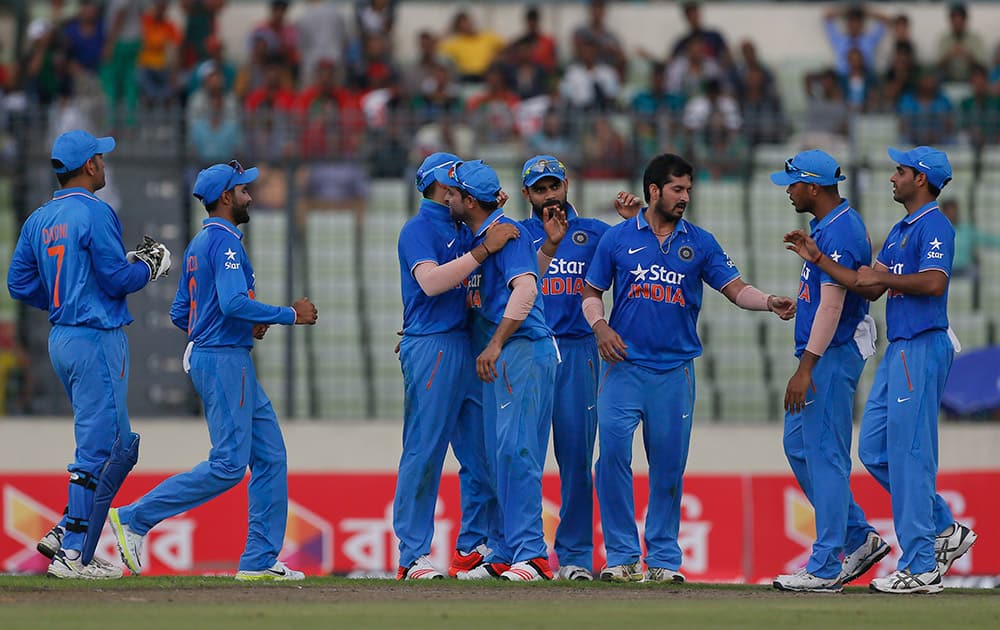 Teammates congratulate India’s Suresh Raina, center, after the dismissal of Bangladesh’s Soumya Sarkar during the first one-day international cricket match in Dhaka, Bangladesh.