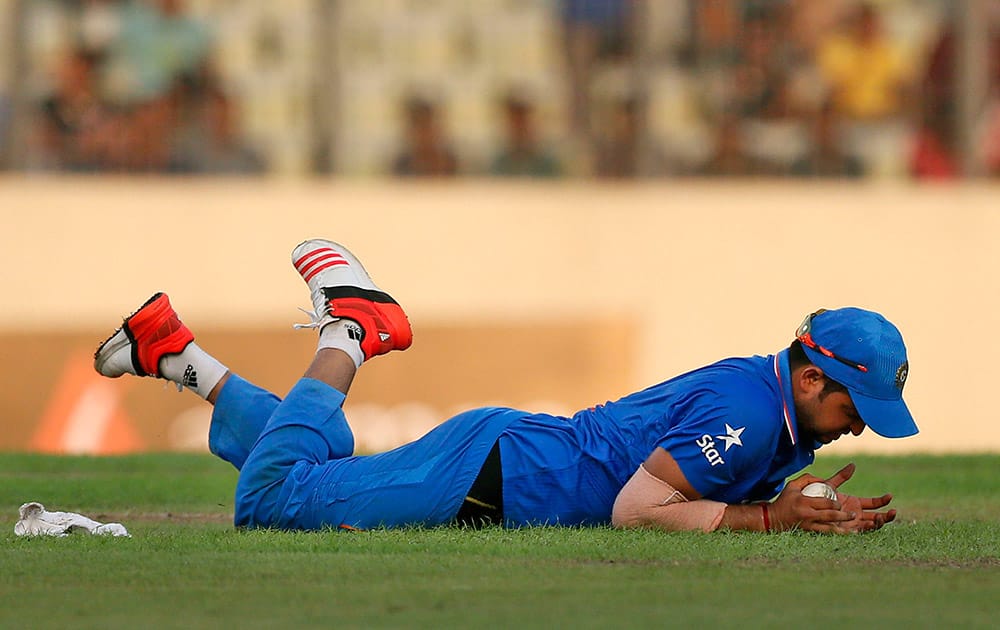 Suresh Raina dives to stop the ball as he fields during the first one-day international cricket match against Bangladesh in Dhaka, Bangladesh.