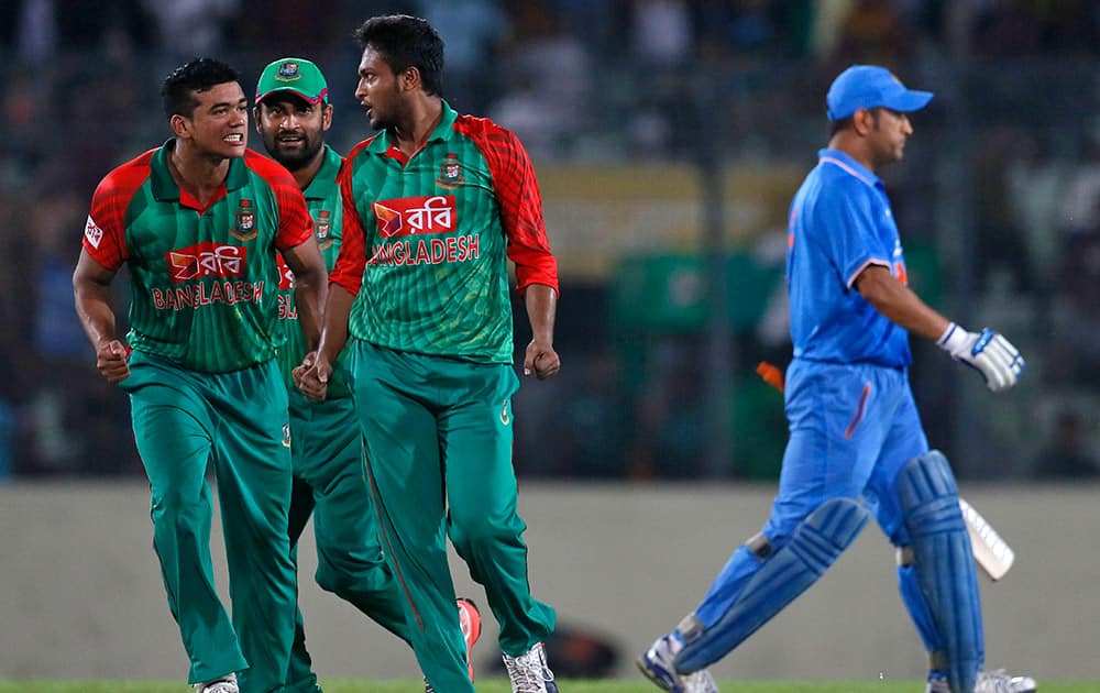 Bangladesh’s Shakib Al Hasan, celebrates with teammates Taskin Ahmed and Tamim Iqbal, the dismissal of MS Dhoni, right, during the first one-day international cricket match between them in Dhaka, Bangladesh