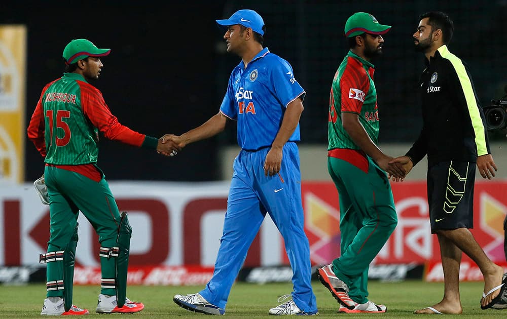 Bangladesh’s team members Mushfiqur Rahim and Tamim Iqbal, shake hands with India’s captain MS Dhoni and Virat Kohli after their win over India during the first one-day international cricket match between them in Dhaka, Bangladesh.