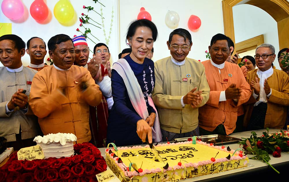 Myanmar's opposition leader Aung San Suu Kyi, cuts her birthday cake as members of her National League for Democracy party sing during a celebration of her 70th birthday at a parliament building, in Naypyitaw, Myanmar. 