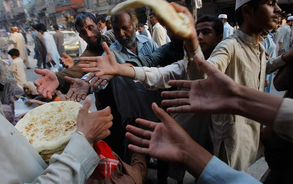 A Pakistani man distributes bread to poor people during a month of Ramadan in Peshawar, Pakistan.