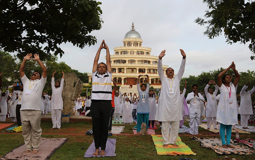 Yoga enthusiasts perform Surya Namaskar or sun salutation as they participate in a prelude to the International Yoga Day at the Art of Living headquarters on the outskirts of Bangalore.