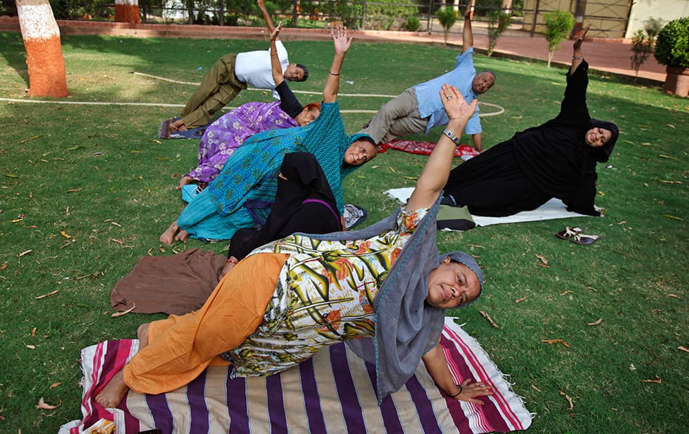 People perform Yoga exercises at a garden in Ahmadabad.