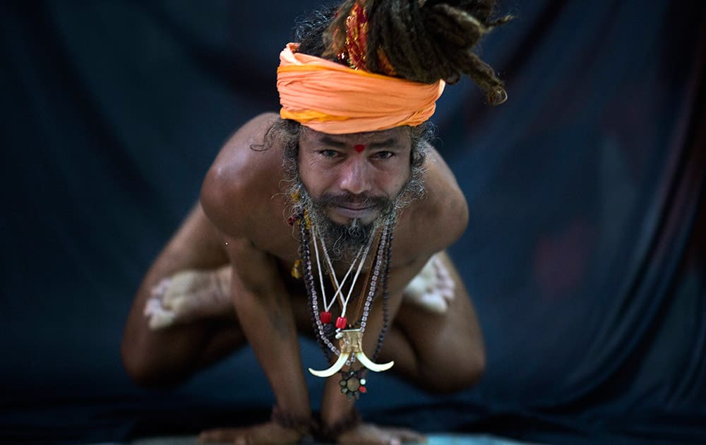 Hindu holy man, illustrates the yoga pose Kakasana, or the crow pose in Guwahati.