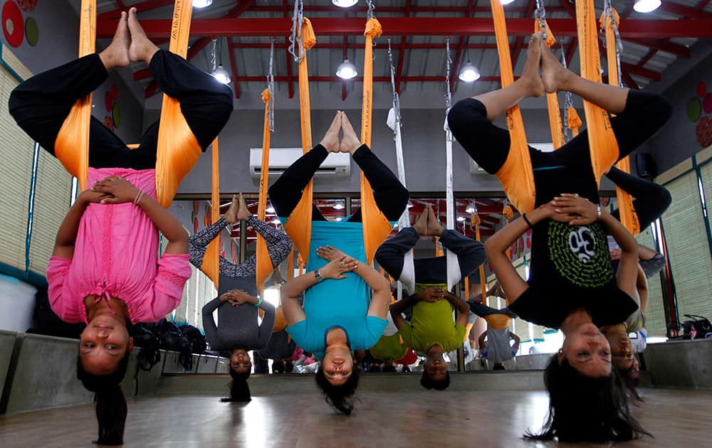 People perform anti gravity aerial yoga in Ahmadabad.