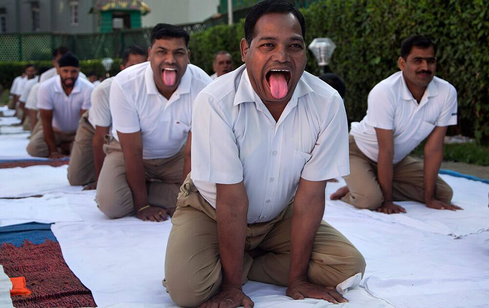 Indian paramilitary soldiers performs yoga exercises inside a base camp in outskirts of Srinagar, Kashmir.