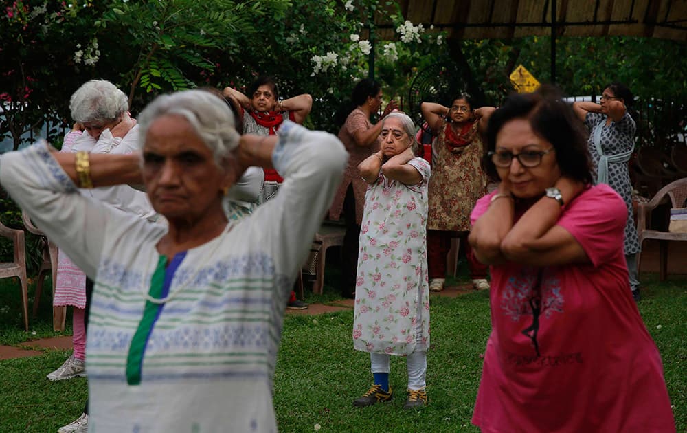 Elderly people perform early morning yoga in a park in Mumbai.