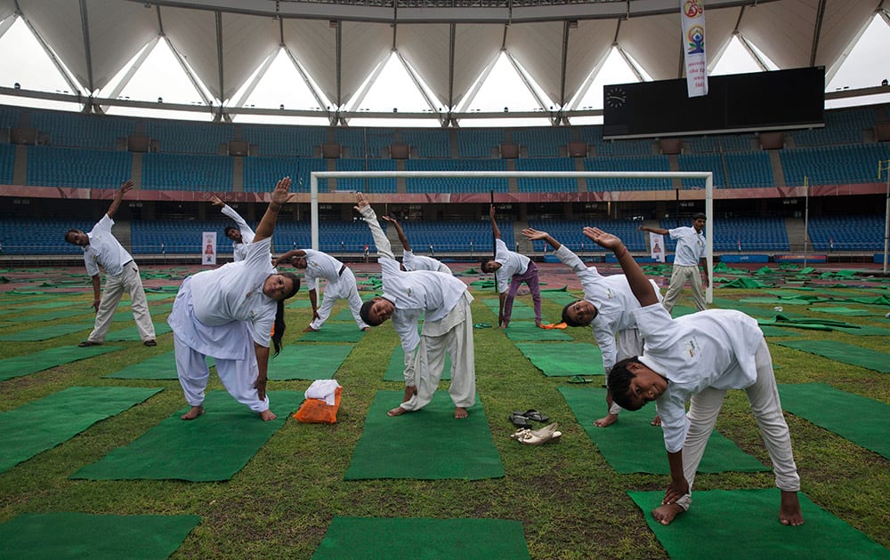 People perform yoga in a stadium in New Delhi.