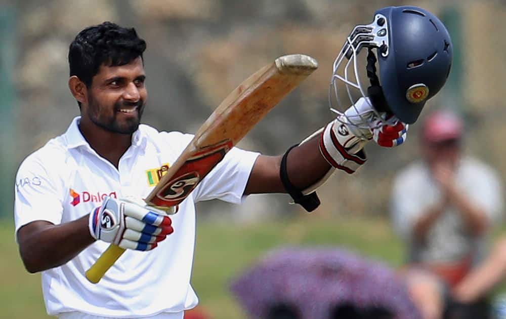 Sri Lanka’s Kaushal Silva raises his bat and helmet after scoring a century during the third day of the first test cricket match against Pakistan at the Galle International Cricket Stadium in Galle, Sri Lanka.