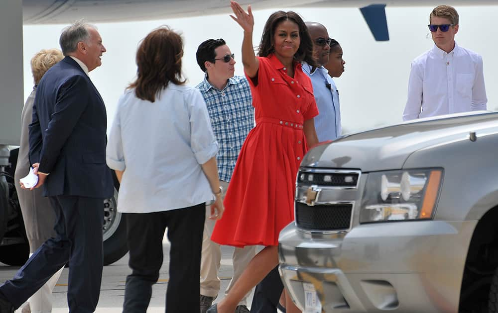 US first lady Michelle Obama waves as she disembarked from a plane as she arrives at Venice's airport.