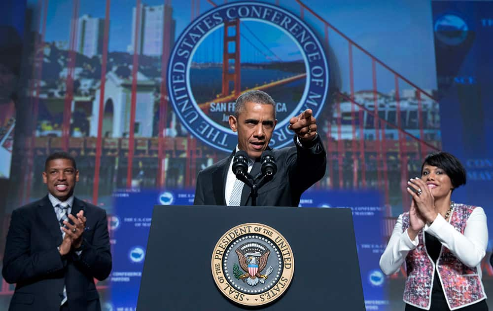 President Barack Obama, joined by Sacramento, Calif., Mayor Kevin Johnson, left, and Baltimore Mayor Stephanie Rawlings-Blake, right, arrives to speak at the Annual Meeting of the U.S. Conference of Mayors in San Francisco.