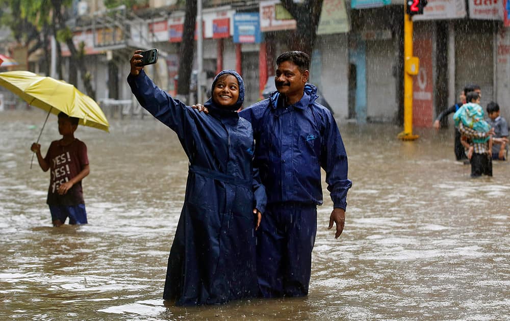 Couple take a selfie on a water-logged street as it rains in Mumbai.