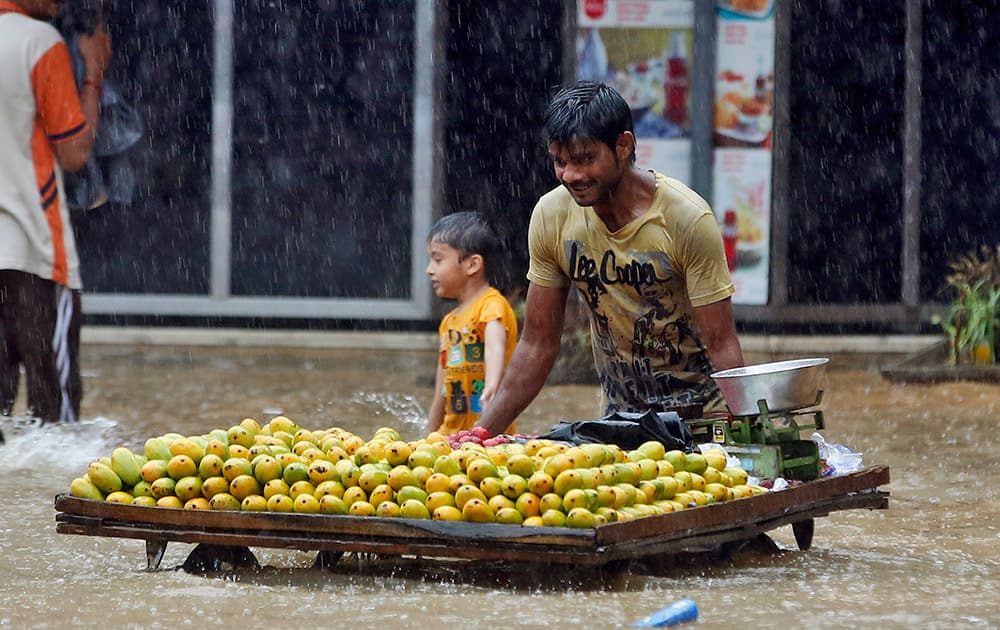 A fruit vendor pushes his cart through a flooded street during monsoon rains in Mumbai.