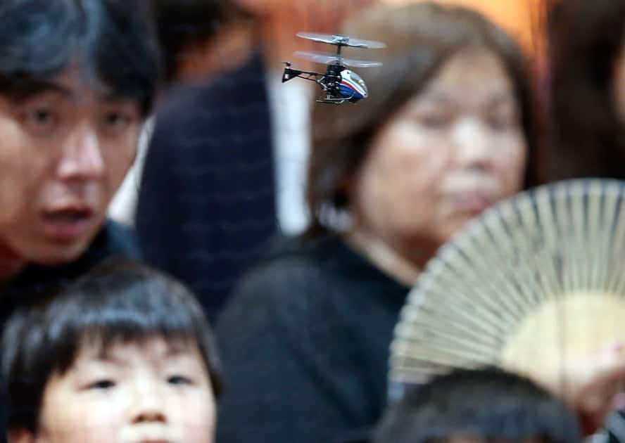 Visitors watch as the world's smallest toy helicopter 'Pico-Falcon' is demonstrated at the International Tokyo Toy Show in Tokyo.