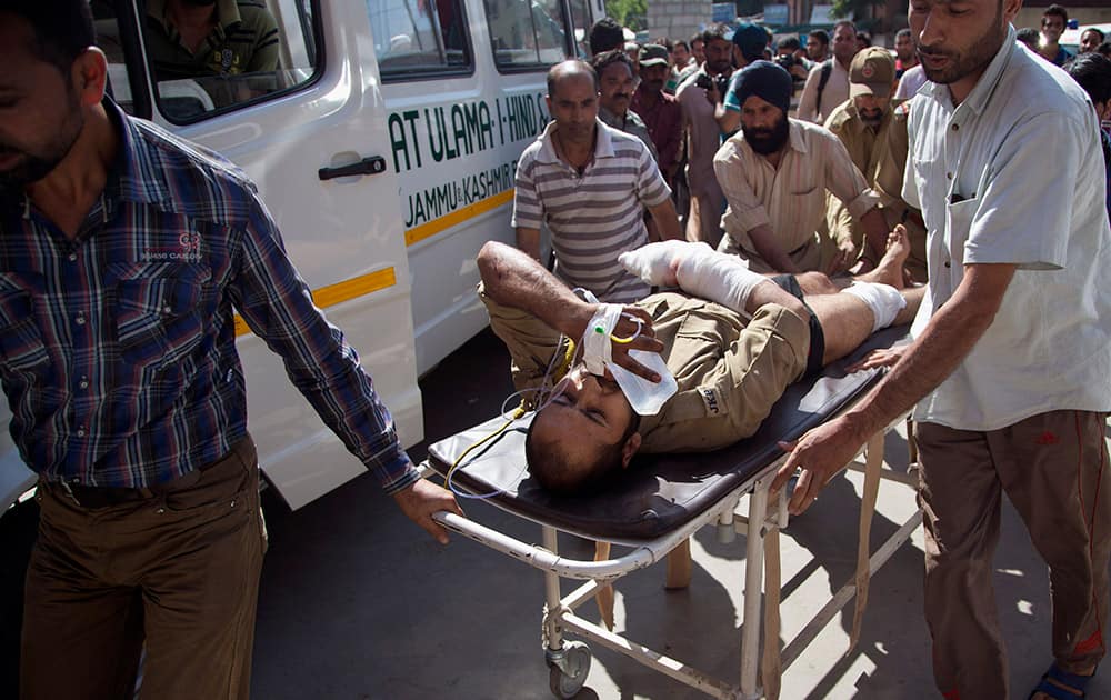 Kashmiri Muslims carry a wounded policeman on a stretcher outside a local hospital in Srinagar. A Pakistani prisoner was killed and five policemen sustained injuries in a suspected blast that took place inside a police vehicle. 