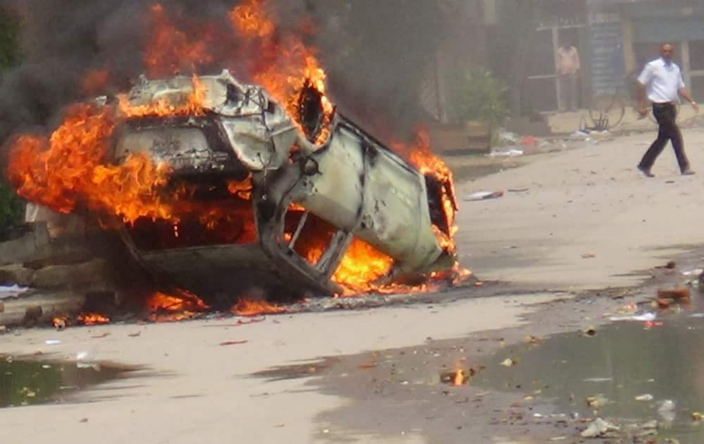 A vehicle in fire after the workers of a company became violent following the rumor of death of a colleague in Gurgaon.