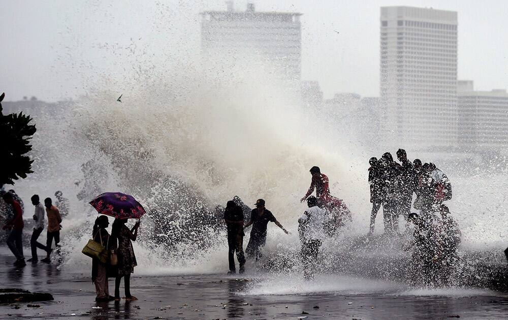 People enjoy high tide during monsoon season in Mumbai.