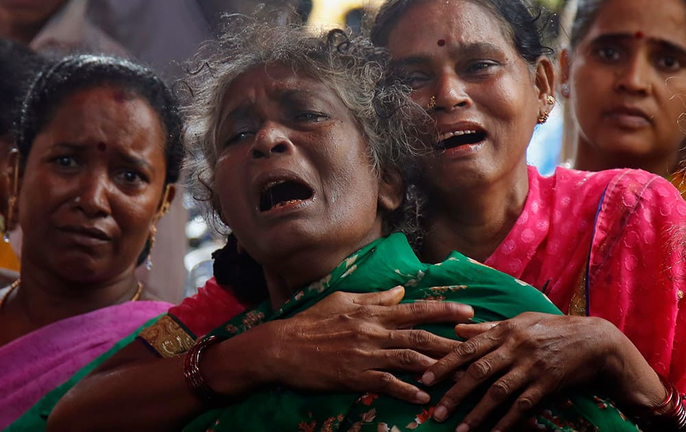 Family members of Raja Ludraswami Harjan, who died after drinking tainted liquor, cry at his funeral in Mumbai. The death toll from drinking tainted liquor in a Mumbai slum climbed to more than 80 in the worst incident of its kind in more than a decade, police said Saturday.