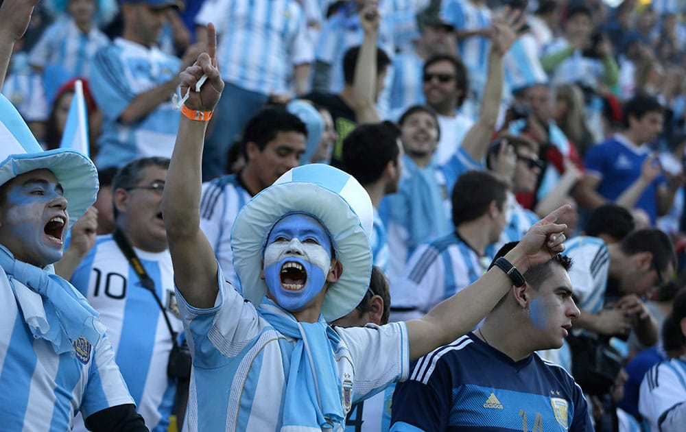 Soccer fans, their faces painted in the colors of Argentina's national soccer team, get revved up as they wait for the start of a Copa America Group B soccer match between Argentina and Jamaica at the Sausalito Stadium in Vina del Mar, Chile.