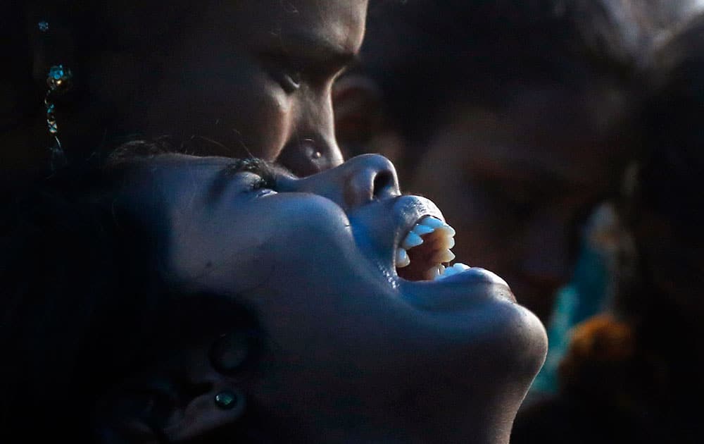 A woman cries over the death of her family member who died after drinking tainted liquor at his funeral in Mumbai, India.