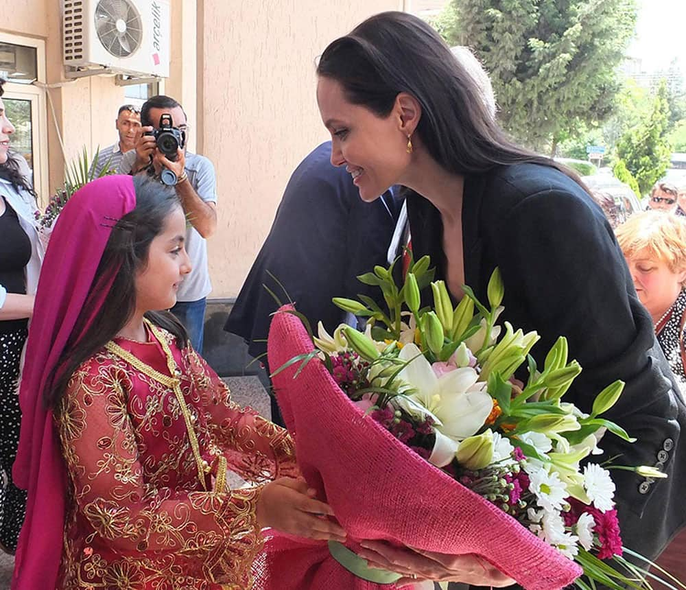 U.S. actress Angelina Jolie, Special Envoy of the United Nations High Commissioner for Refugees receives flowers as she is welcomed by a girl on arrival at the mayor’s office in Mardin.