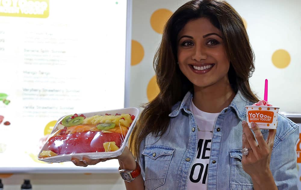 Bollywood actress Shilpa Shetty Kundra poses for a photograph with a frozen yogurt during its store launch in Bengaluru.