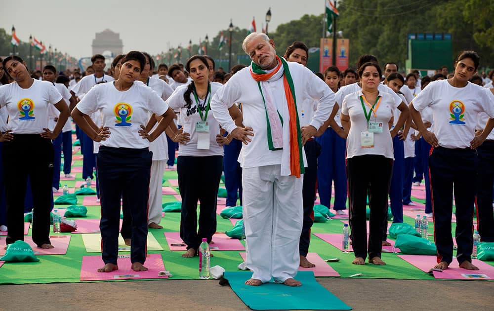 Prime Minister Narendra Modi performs yoga along with thousands of Indians on Rajpath, in New Delhi, India.