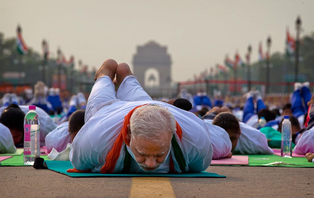 Prime Minister Narendra Modi lies down on a mat as he performs yoga along with thousands of Indians on Rajpath, in New Delhi, India.