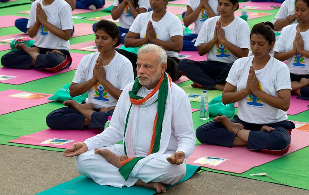 Prime Minister Narendra Modi, center front, performs yoga along with thousands of Indians on Rajpath, in New Delhi, India.