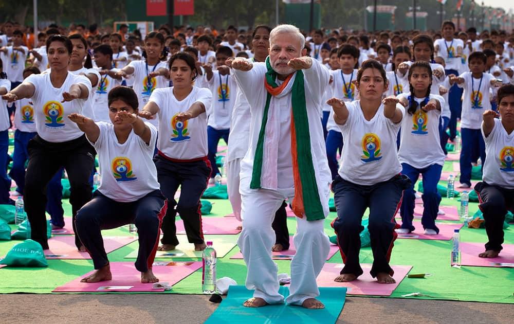 Prime Minister Narendra Modi performs yoga along with thousands of Indians on Rajpath, in New Delhi, India.