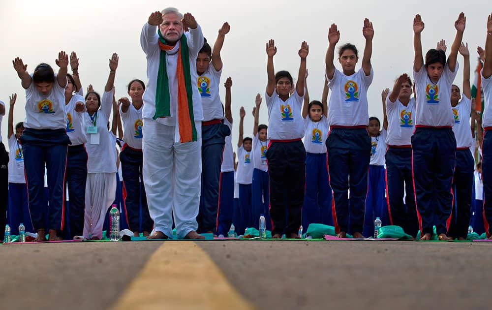 Prime Minister Narendra Modi performs yoga along with thousands of Indians on Rajpath, in New Delhi, India.