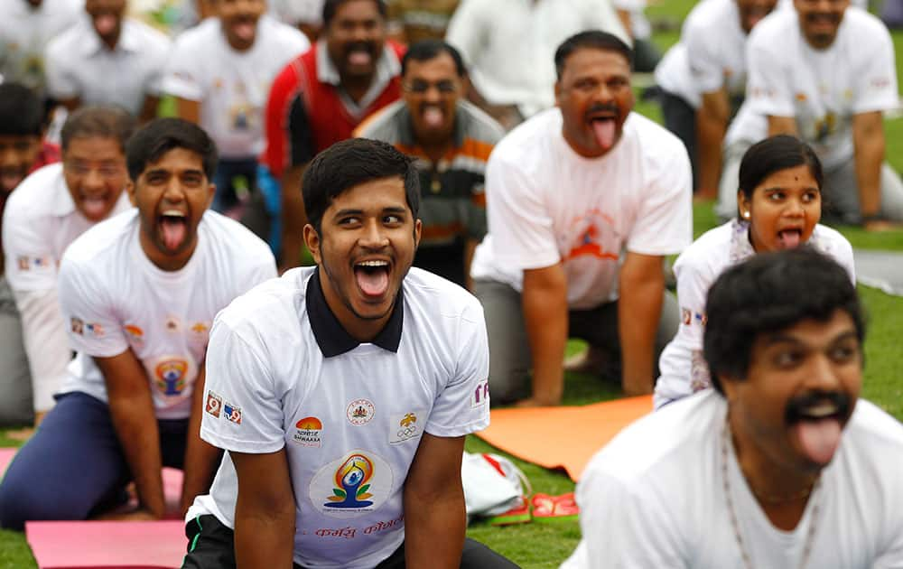 Indians perform yoga at an event to celebrate the International Yoga Day in Bangalore, India.