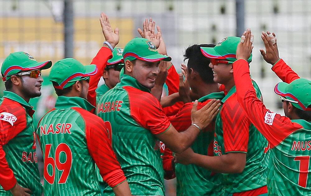 Bangladesh’s players celebrate the dismissal of India’s Rohit Sharma during their second one-day international cricket match in Dhaka, Bangladesh.