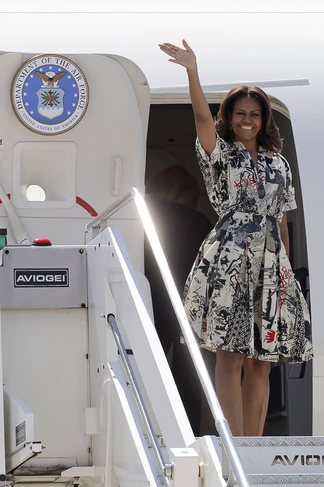 US First lady Michelle Obama waves as she boards a plane at Venice's airport.