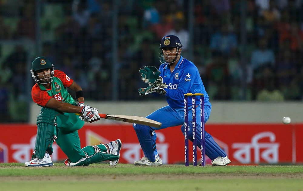 Bangladesh’s Litton Das, left, plays a shot, as India’s captain M S Dhoni watches during their second one-day international cricket match in Dhaka, Bangladesh.