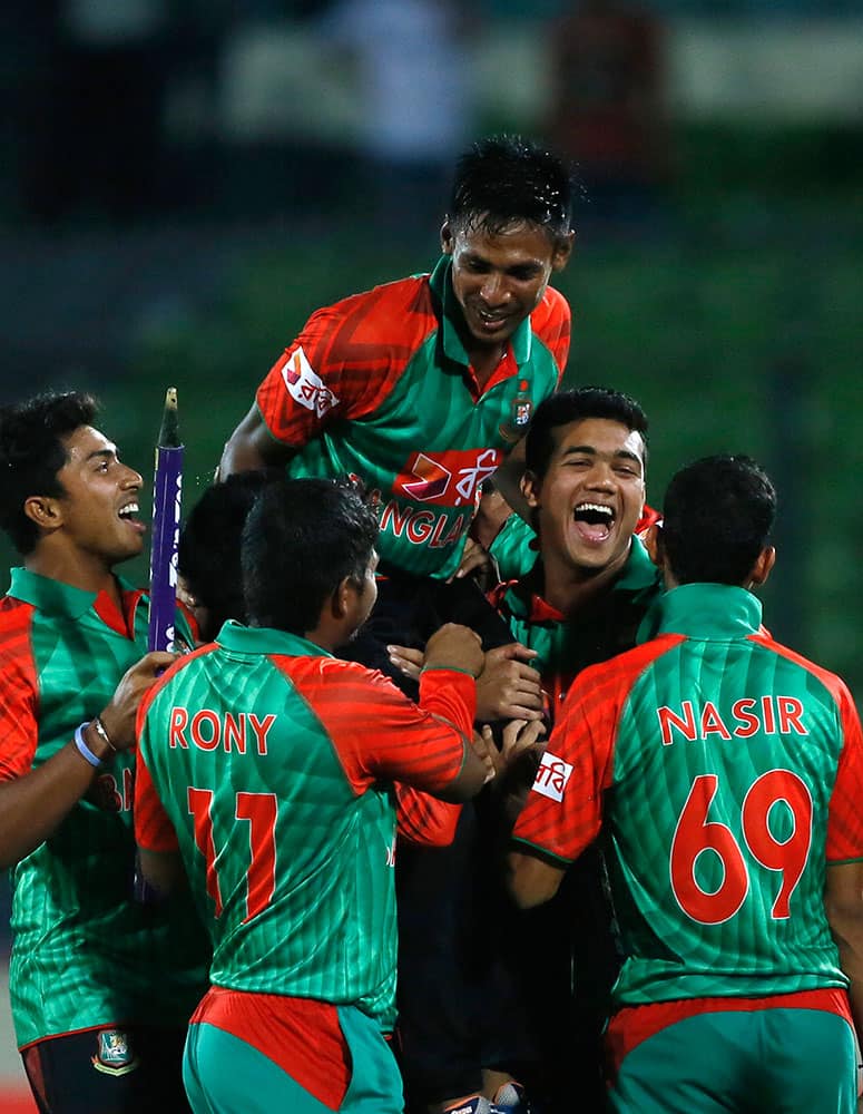 Bangladesh’s players lift Mustafizur Rahman, center, as they celebrate their win over India during their second one-day international cricket match in Dhaka, Bangladesh.