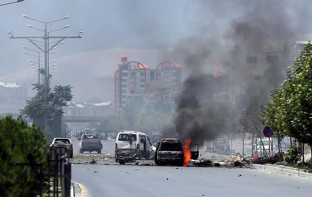 Fire and smokes rise at the site of a suicide attack during clashes with Taliban fighters in front of the Parliament, in Kabul, Afghanistan.
