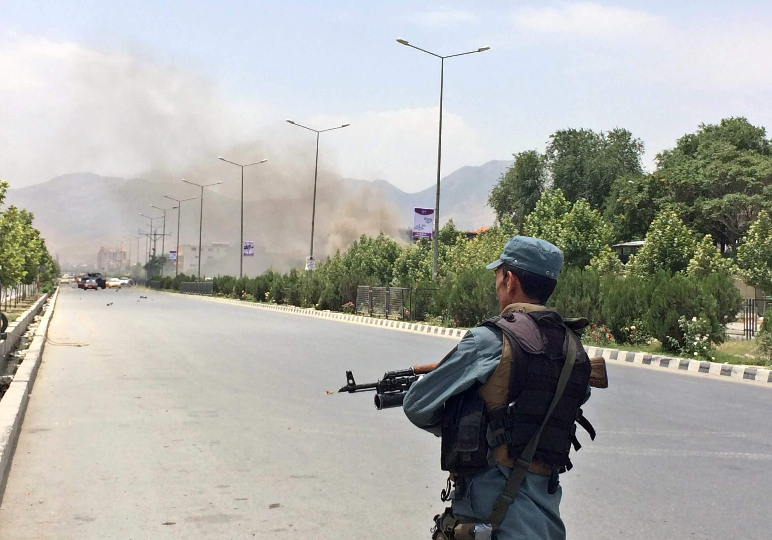 An Afghan security officer stands guard at the entry gate of the Afghan parliament after an attack by the Taliban, in Kabul, Afghanistan.